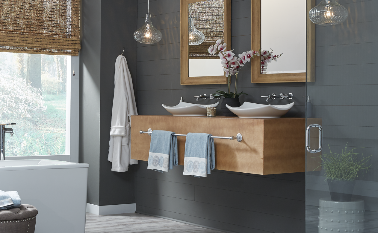 floating light wood vanity with white sinks and silver hardware in grey bathroom with light grey flooring